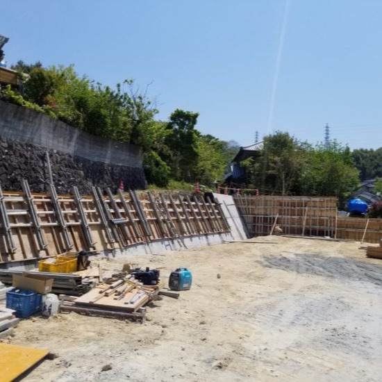 擁壁の型枠が組まれ、コンクリート打設準備が進む実際の施工現場の写真